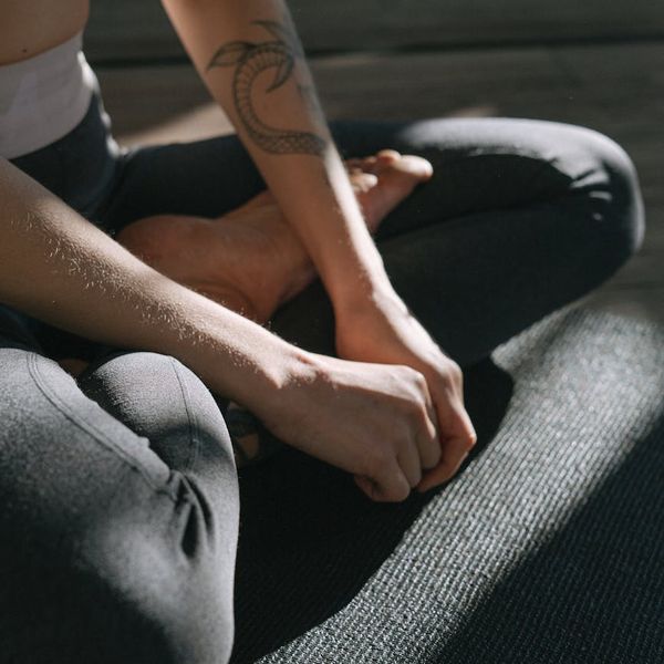 Person sitting in a meditative yoga pose with a calm expression.